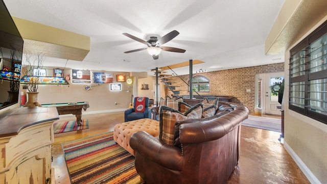 living room featuring ceiling fan, pool table, brick wall, and concrete flooring