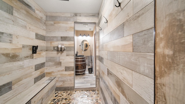 bathroom with wooden walls and a shower