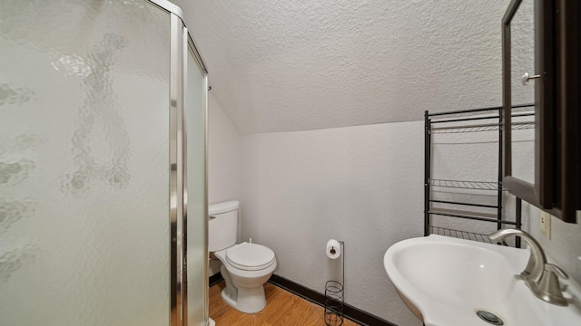 bathroom with lofted ceiling, sink, hardwood / wood-style flooring, an enclosed shower, and toilet