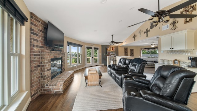 living room featuring lofted ceiling, hardwood / wood-style floors, a fireplace, and french doors