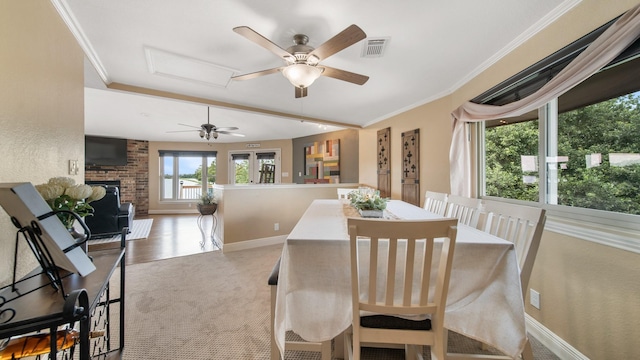 dining room featuring crown molding, ceiling fan, carpet flooring, and a brick fireplace