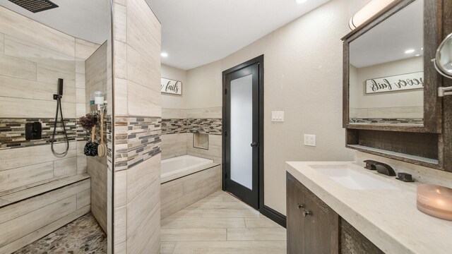 bathroom featuring vanity and plus walk in shower