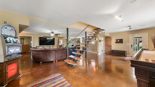 living room with ceiling fan and concrete floors