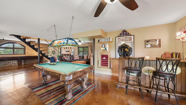 rec room featuring bar area, billiards, ceiling fan, and brick wall