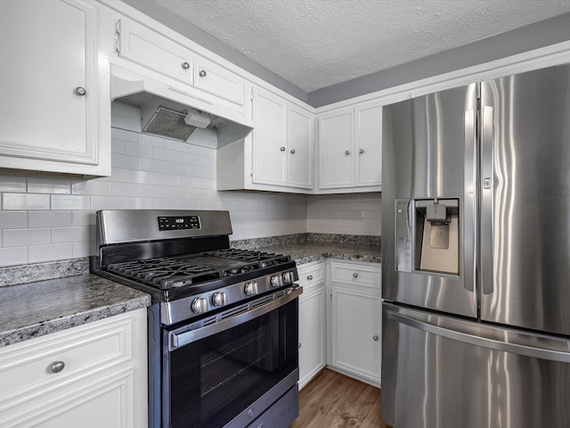 kitchen featuring stainless steel appliances, light wood-type flooring, a textured ceiling, and white cabinetry