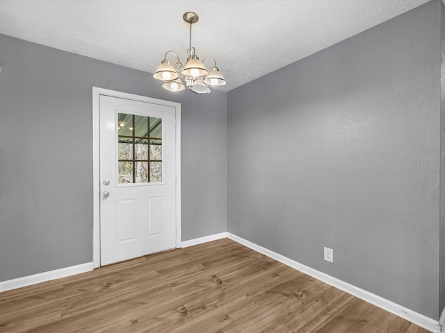 interior space featuring hardwood / wood-style floors, an inviting chandelier, and a textured ceiling