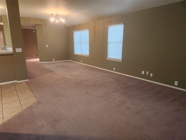 tiled empty room featuring sink and a notable chandelier