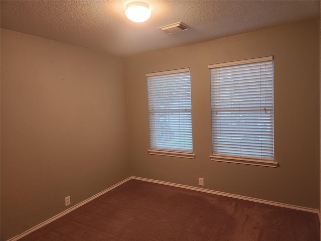 unfurnished room featuring a textured ceiling