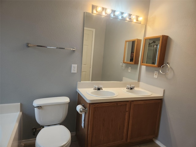 bathroom featuring vanity, toilet, and a washtub