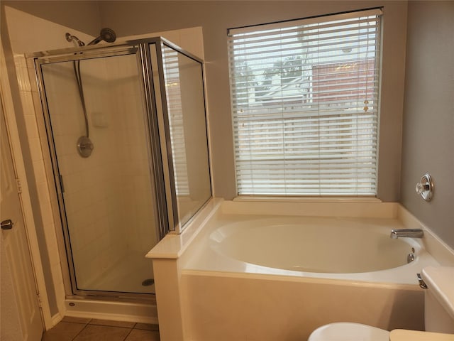 bathroom with tile patterned flooring, separate shower and tub, and toilet