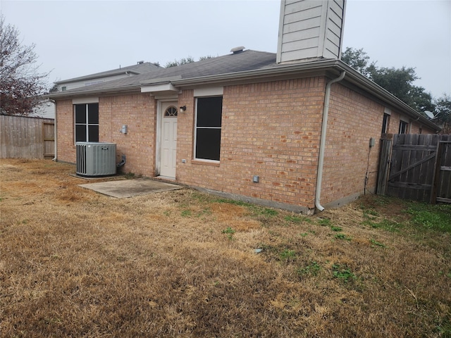 back of property featuring a yard and central AC unit