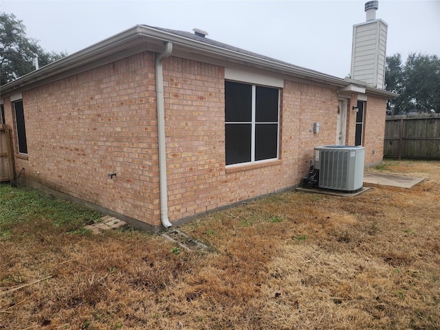 view of property exterior featuring a yard and central AC