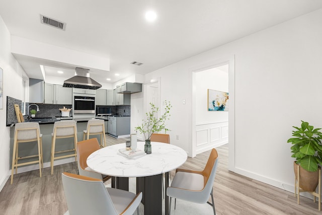 dining area with light hardwood / wood-style flooring and sink