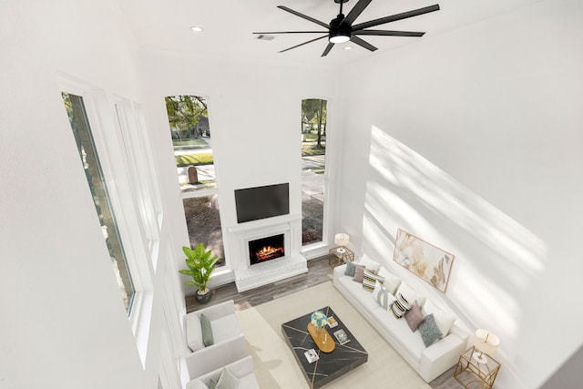 living room with ceiling fan, crown molding, and hardwood / wood-style floors