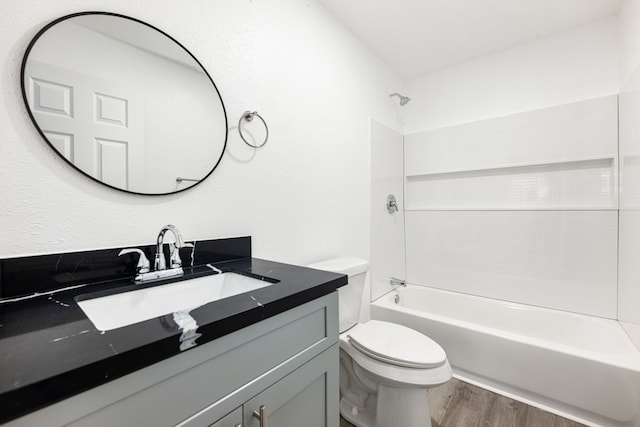 full bathroom with toilet, hardwood / wood-style floors, shower / washtub combination, and vanity