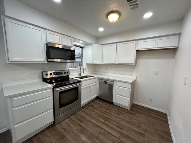 kitchen featuring white cabinetry, appliances with stainless steel finishes, dark hardwood / wood-style flooring, and sink