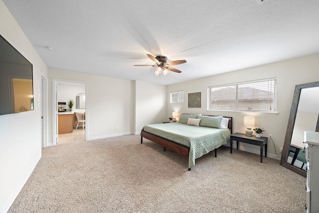 bedroom featuring a textured ceiling, ceiling fan, and light colored carpet