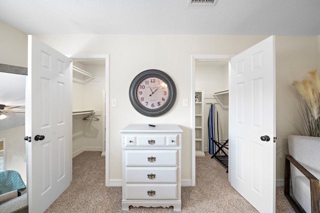 spacious closet featuring light colored carpet and ceiling fan