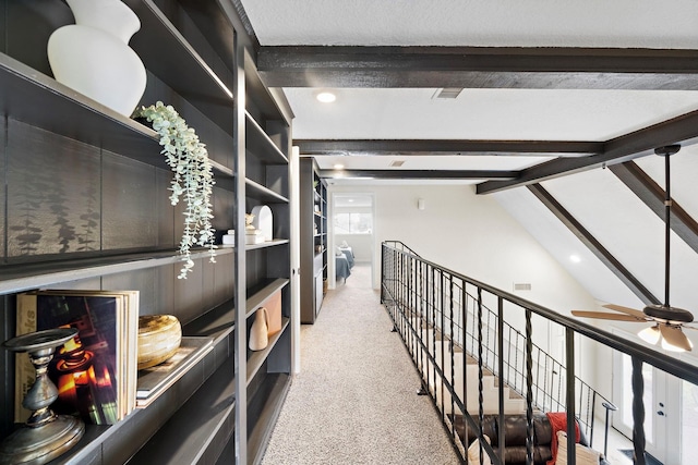 interior space with light colored carpet, built in features, and vaulted ceiling with beams