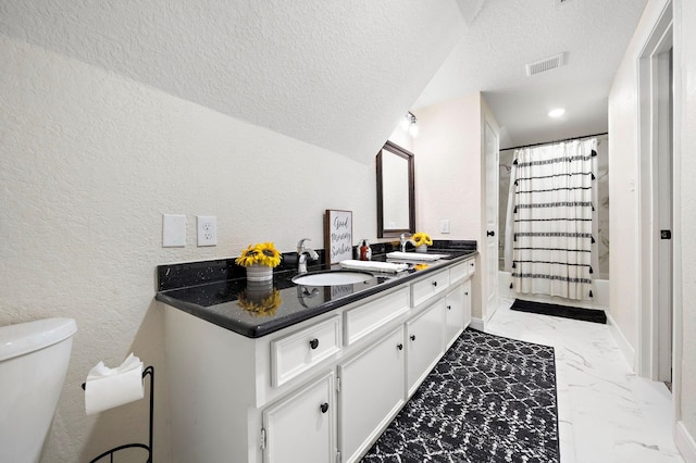 full bathroom featuring toilet, vanity, shower / bath combo, and a textured ceiling