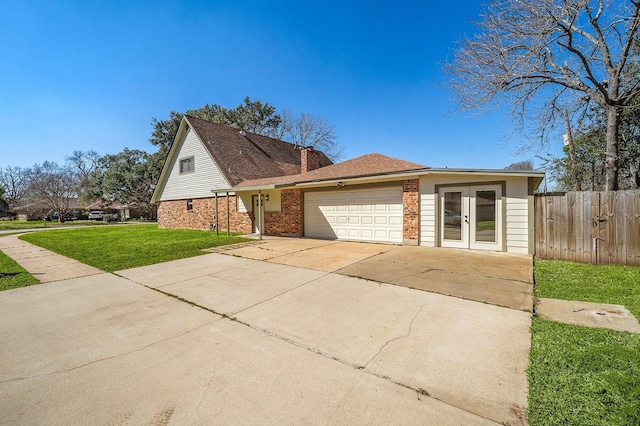 view of front of house featuring french doors, a front lawn, and a garage