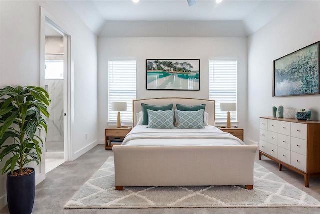 bedroom featuring light colored carpet, connected bathroom, and vaulted ceiling