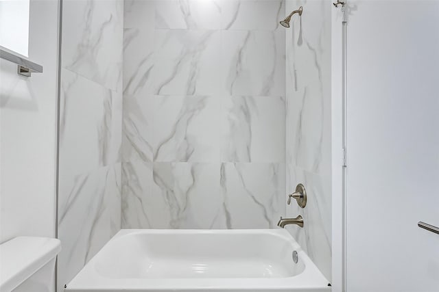 bathroom with tiled shower / bath and toilet