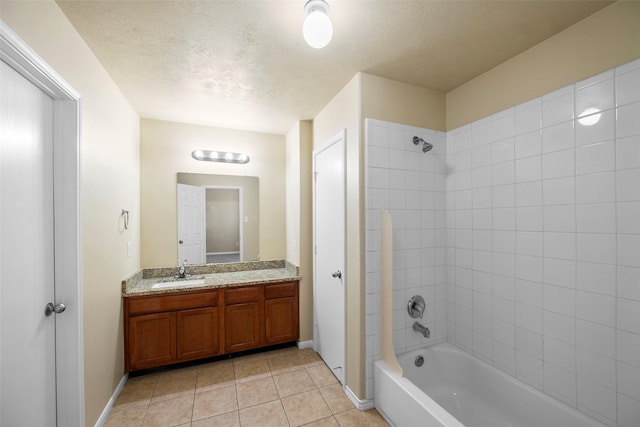 bathroom with vanity, tile patterned floors, tiled shower / bath combo, and a textured ceiling