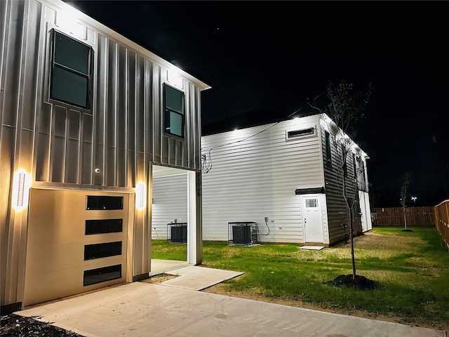 property exterior at twilight with central AC and a yard