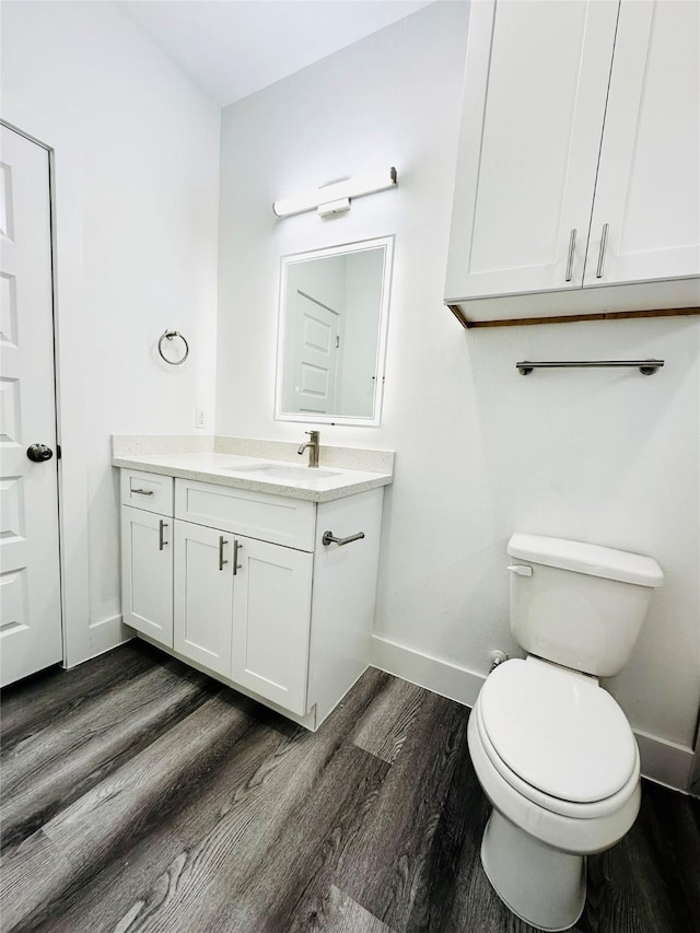 bathroom featuring toilet, hardwood / wood-style floors, and vanity