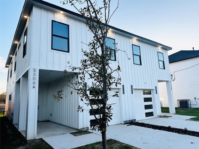 view of front of house with central air condition unit and a garage