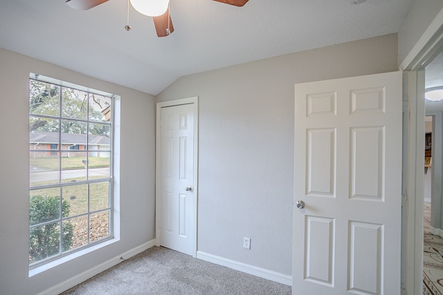 unfurnished bedroom featuring ceiling fan, carpet, a closet, and vaulted ceiling