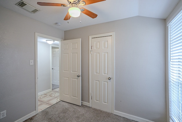 unfurnished bedroom featuring ceiling fan, light colored carpet, and vaulted ceiling