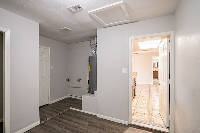 hallway featuring dark wood-type flooring, a textured ceiling, and gas water heater