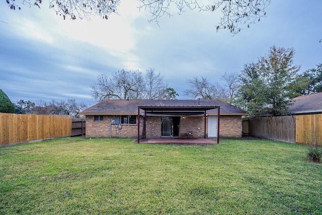 rear view of house featuring a lawn and a patio area