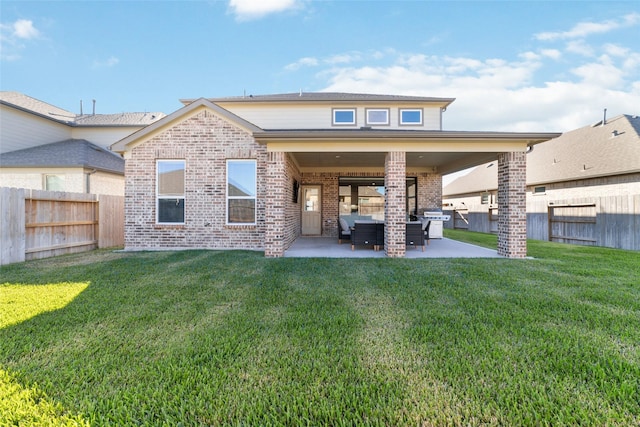 rear view of house featuring a patio, a yard, and an outdoor living space