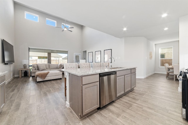 kitchen featuring light stone counters, stainless steel appliances, light hardwood / wood-style floors, and sink