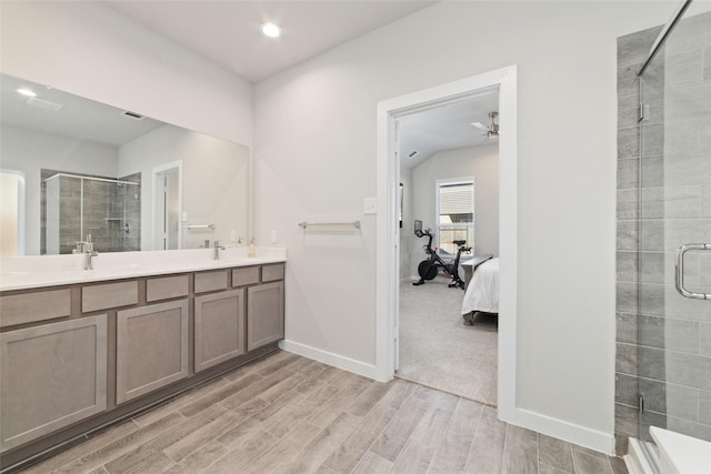 bathroom with a shower with door, ceiling fan, and vanity