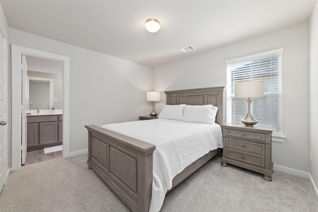 carpeted bedroom with sink, ensuite bathroom, and multiple windows