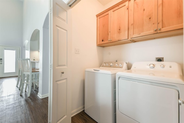 clothes washing area with dark wood-type flooring, cabinets, and separate washer and dryer