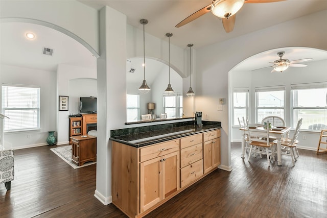 kitchen with vaulted ceiling, ceiling fan, light brown cabinetry, pendant lighting, and dark wood-type flooring