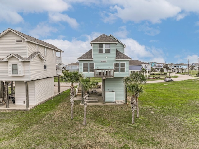 rear view of property featuring a balcony, a patio area, and a yard