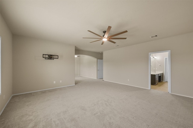 spare room featuring ceiling fan and light carpet