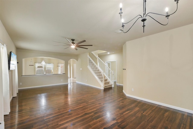 unfurnished living room featuring ceiling fan with notable chandelier and dark hardwood / wood-style flooring