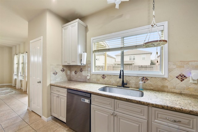 kitchen with sink, white cabinets, dishwasher, light tile patterned floors, and tasteful backsplash