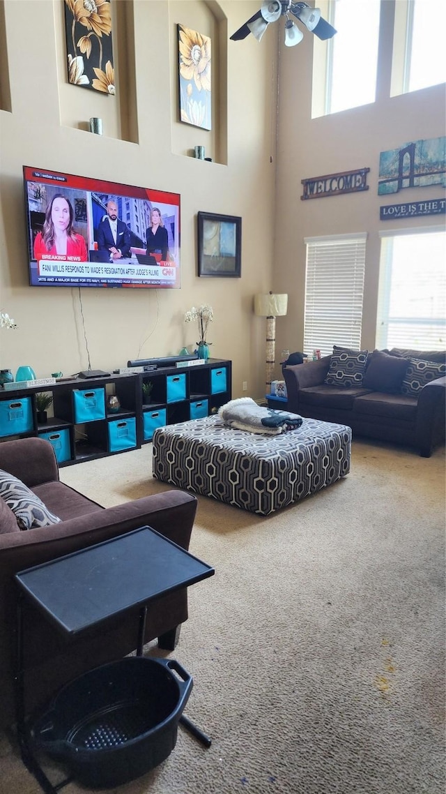 living room with a high ceiling, a wealth of natural light, and carpet