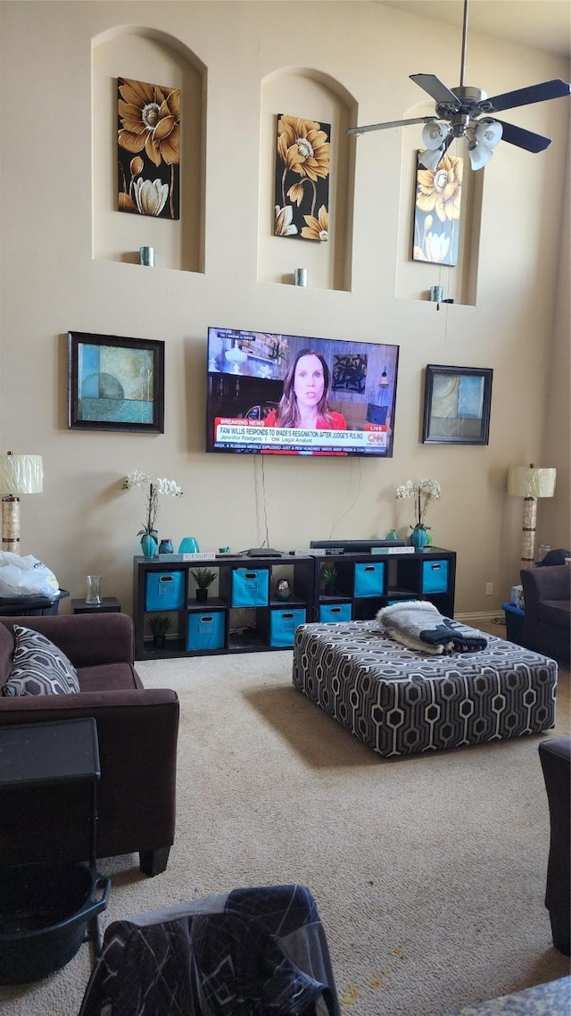 carpeted living room with ceiling fan