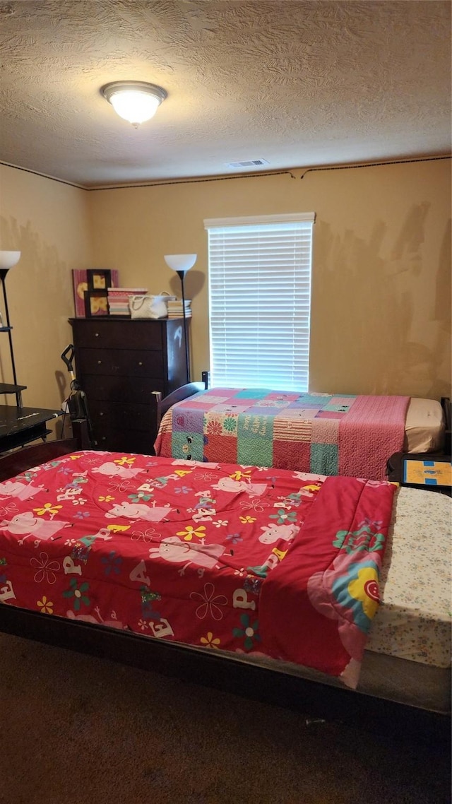 carpeted bedroom featuring a textured ceiling