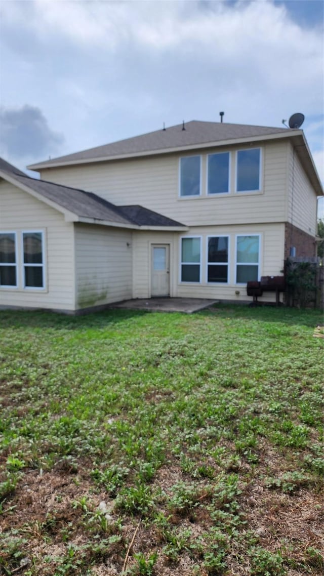 back of property with a patio and a lawn