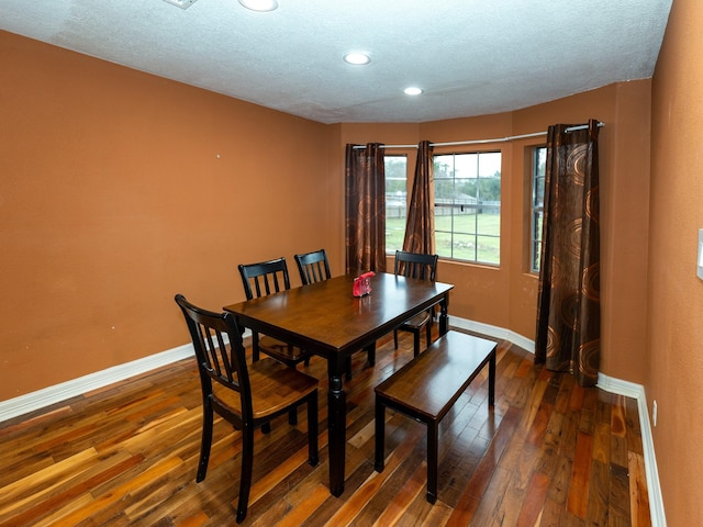 dining space featuring dark hardwood / wood-style flooring and a textured ceiling